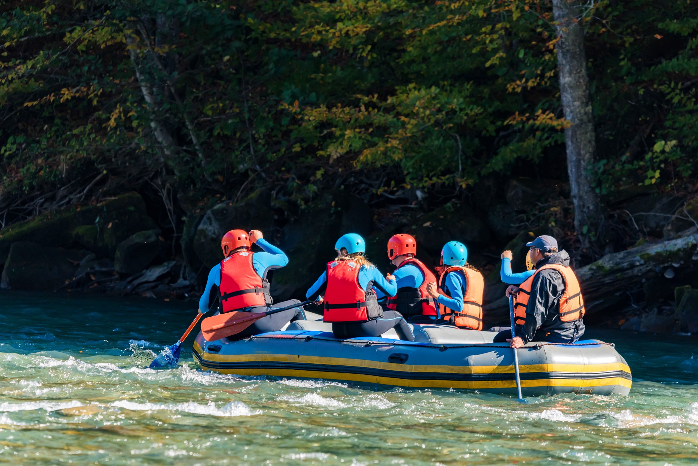 Group of young people going white water rafting